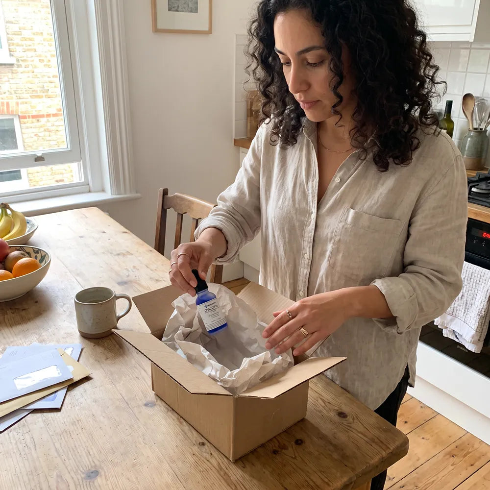 Woman unboxing her Baltic Beauty order at the kitchen table