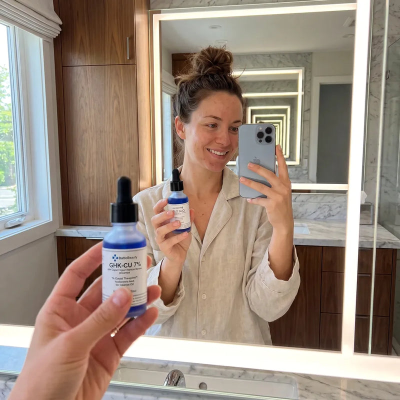 Woman taking a mirror selfie holding the serum bottle